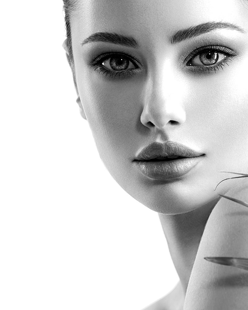 Black and white close-up of a woman with glowing skin, inspired by facials in Nassau County, NY.