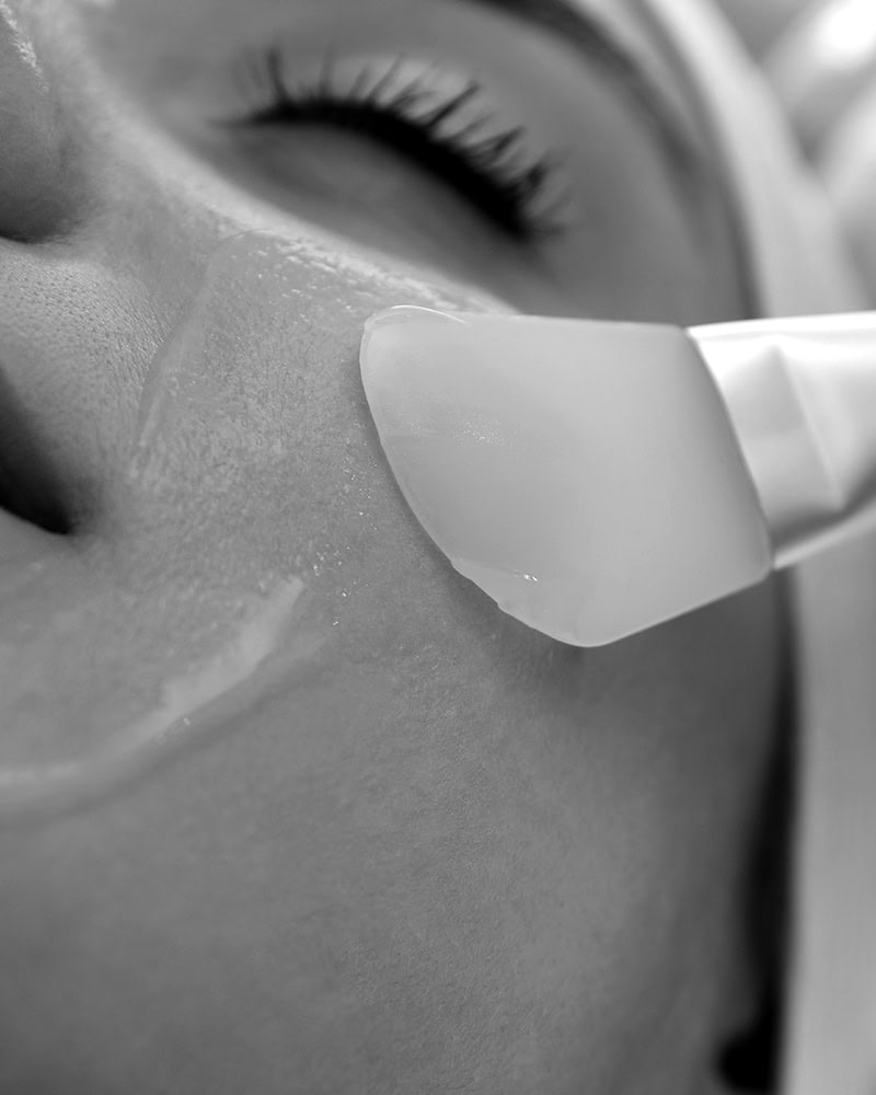 A client receives a gel facial with a spatula at a Medical Spa Nassau County, focusing on the cheek area.